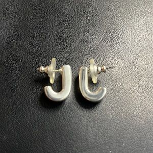 Sterling silver “J” hoops.